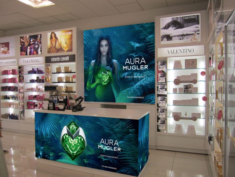 Retail site dressing - featuring a counter clad and lightbox graphics - for Aura by Mugler